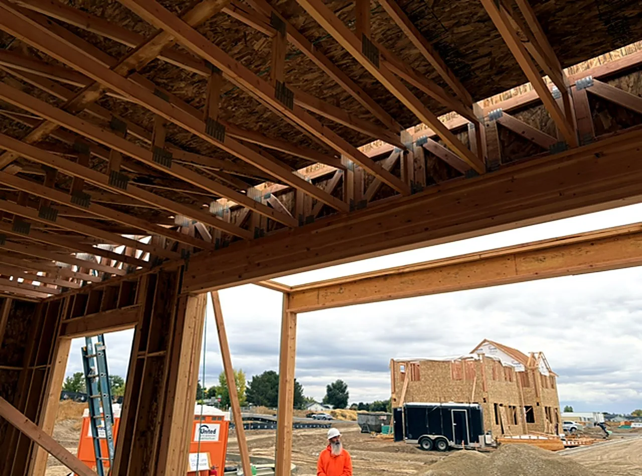 Roof trusses and headers framed over an open garage bay