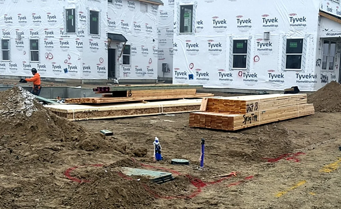 Windows set in a wrapped two-story building with lumber staged in front